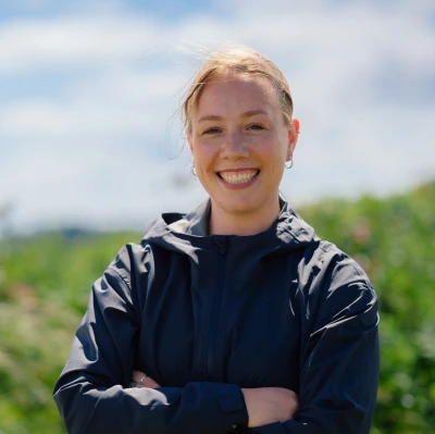 Lady smiling at camera standing on sand dune